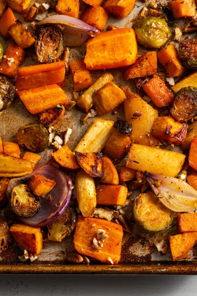 closeup overhead shot of roasted sheet pan fall veggies with burnished edges.