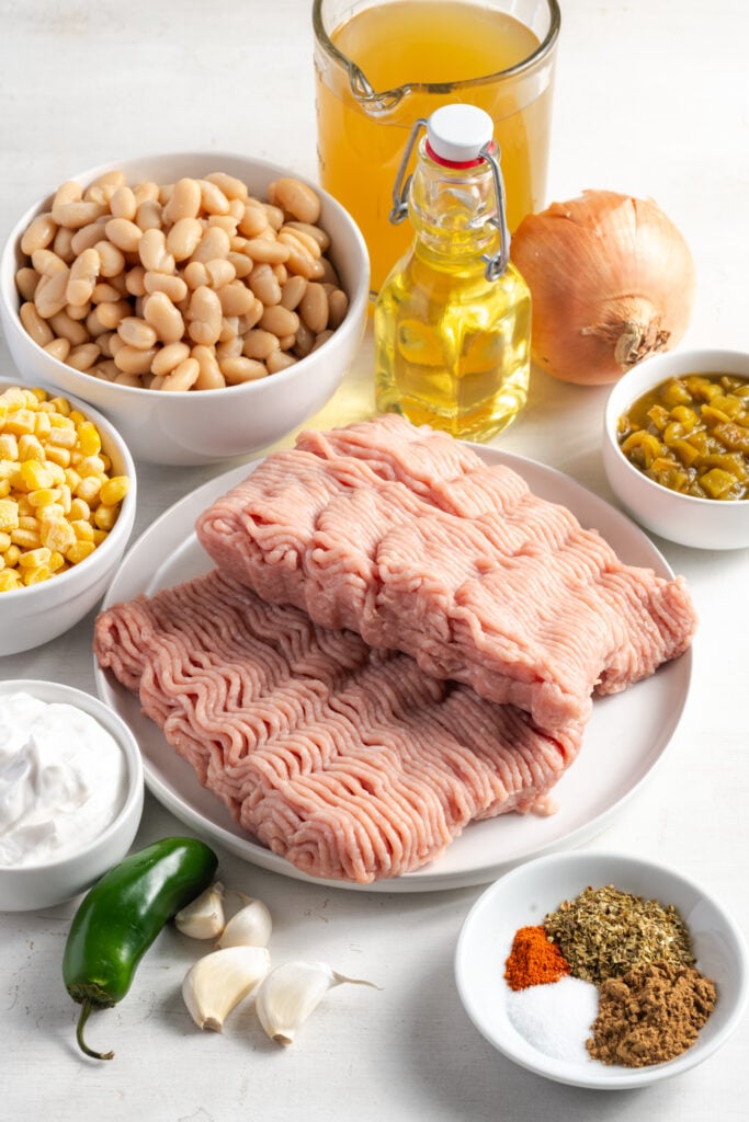 ingredients needed to make white bean turkey chili recipe measured out on a white table.