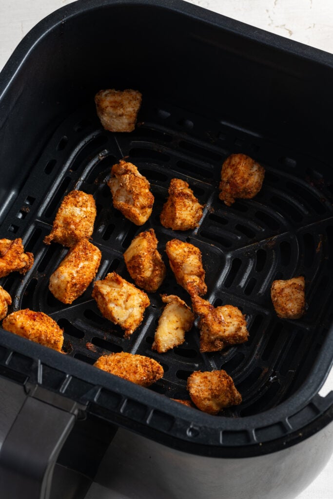 air fried chicken bites in the air fryer basket.