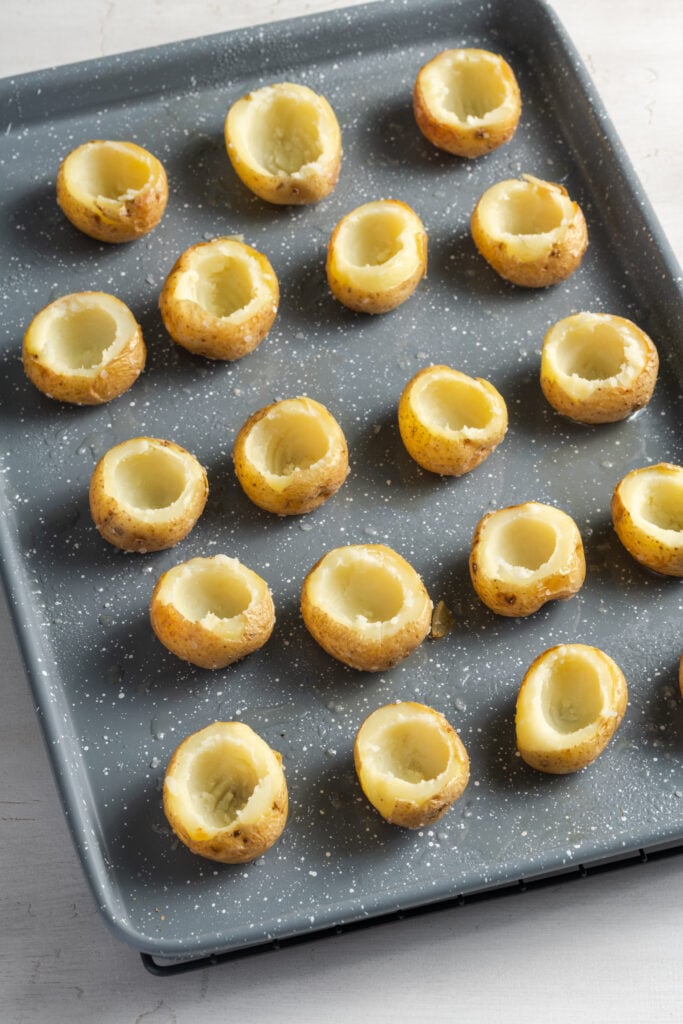 hollowed out baked baby potatoes on a baking sheet.