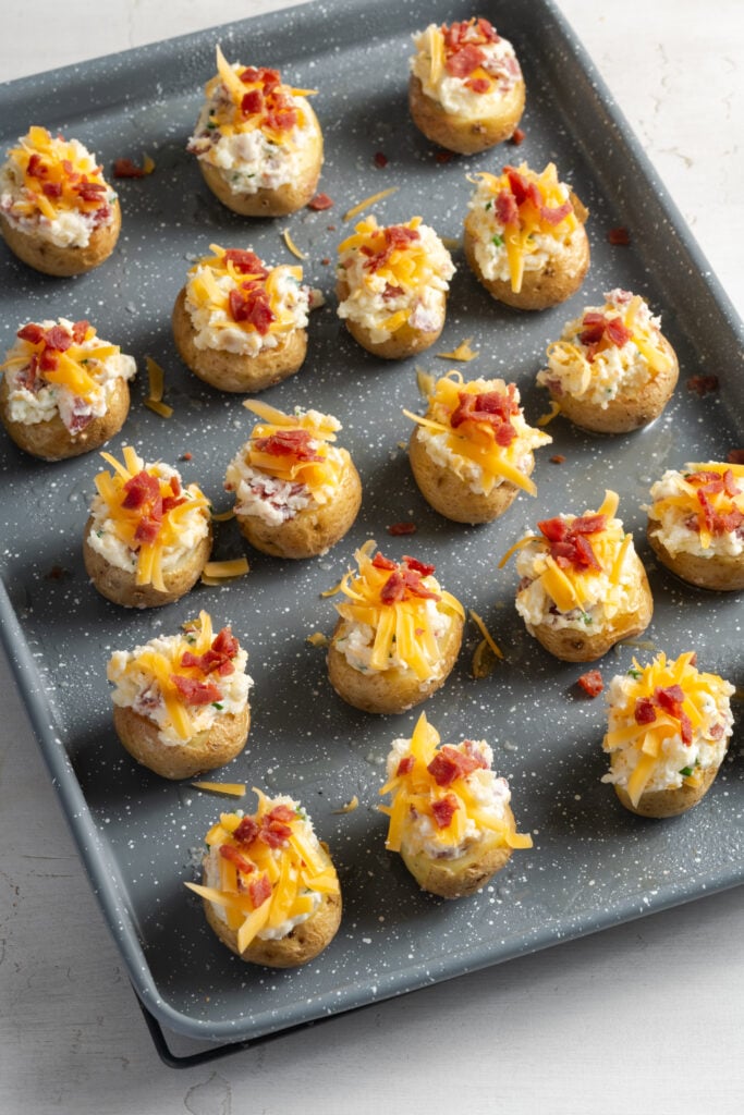 stuffed mini baked potatoes topped with cheese and bacon bits before baking the second time.
