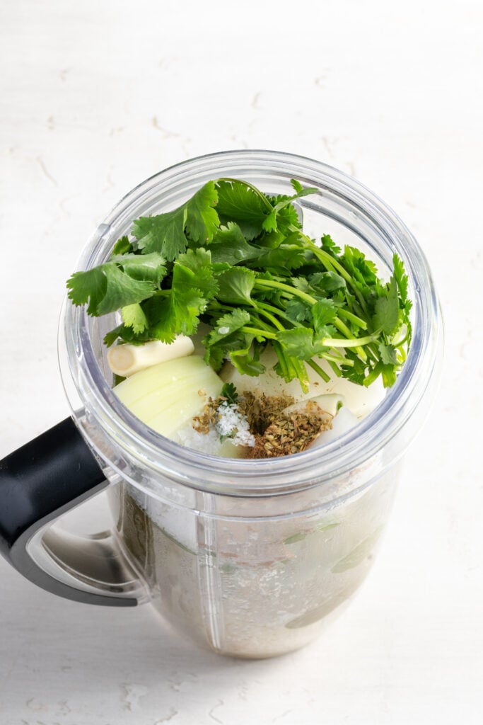 ingredients for making green enchilada sauce added to a blender.