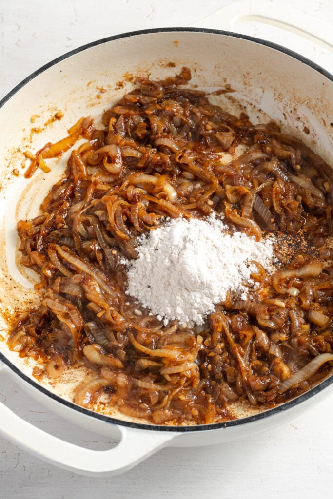flour added to the pan with the cooked onions that are deep golden brown.
