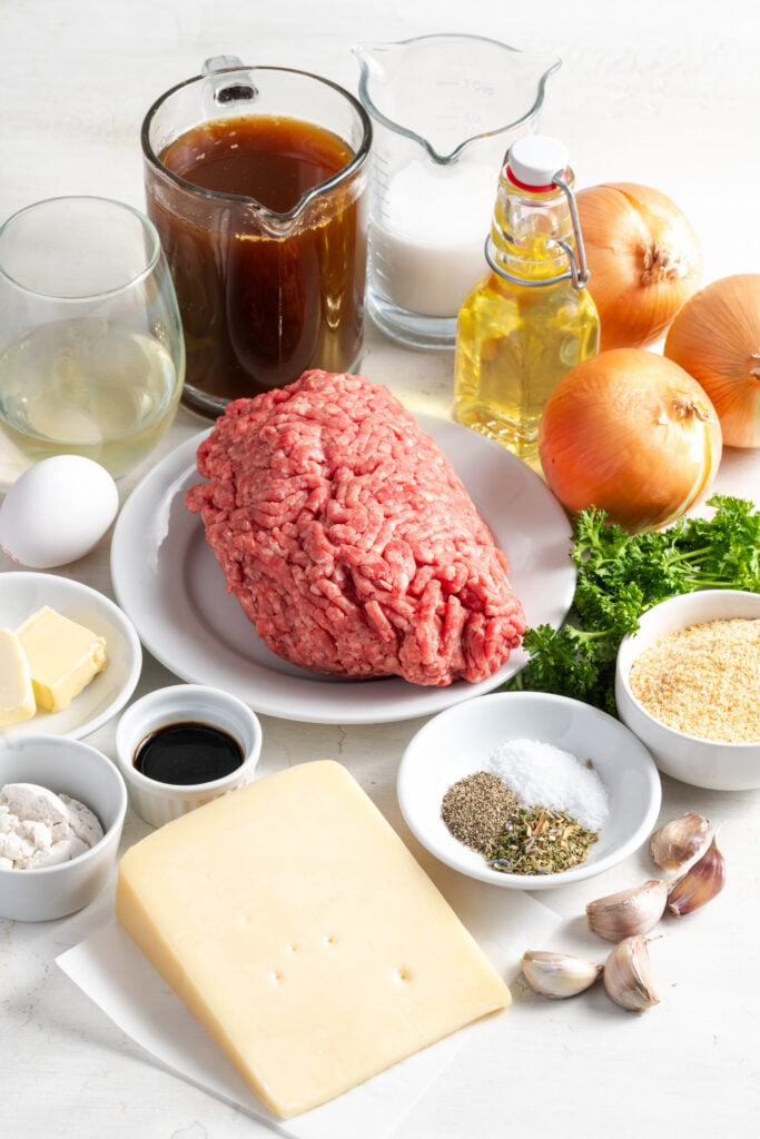 ingredients needed to make french onion meatballs recipe measured out on a white table.