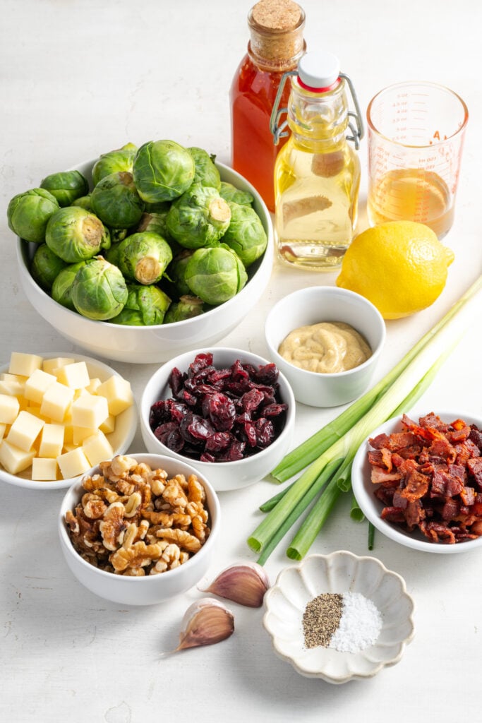 ingredients needed to make shaved brussels sprouts salad recipe measured out on a white table.