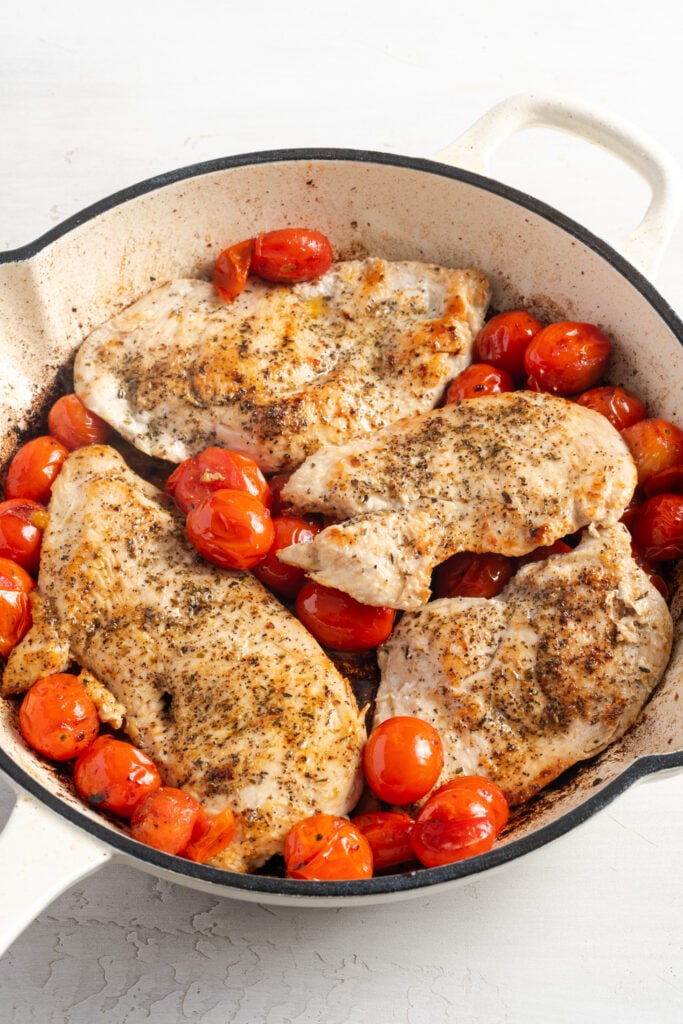 cherry tomatoes and chicken in the skillet after roasting.