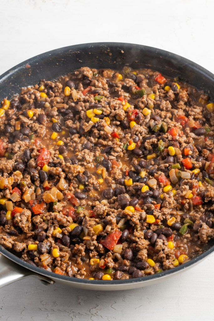 beef, veggie, and black bean filling for stuffed sweet potatoes sauteing in a pan.