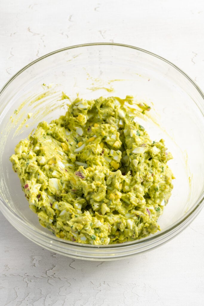 avocado egg salad in a mixing bowl after stirring together.
