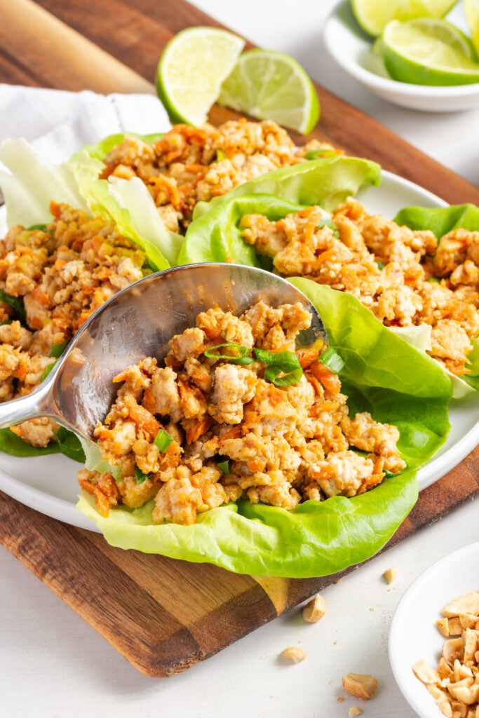 closeup shot of a silver serving spoon spooning the ground turkey mixture into lettuce wraps.