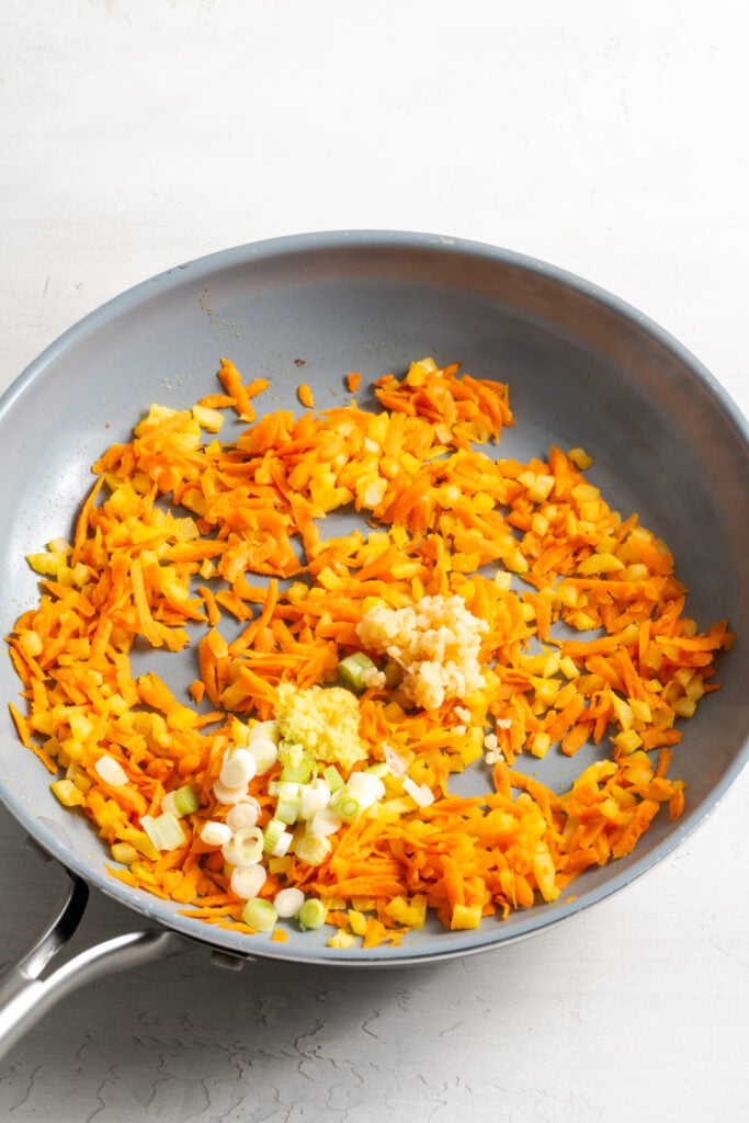 green onions, garlic, and ginger added to the pan with the shredded carrots and water chestnuts.
