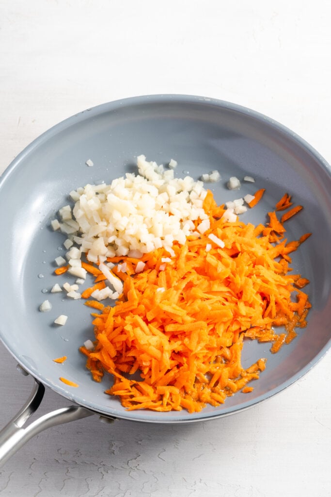 shredded carrots and chopped water chestnuts in a saute pan.