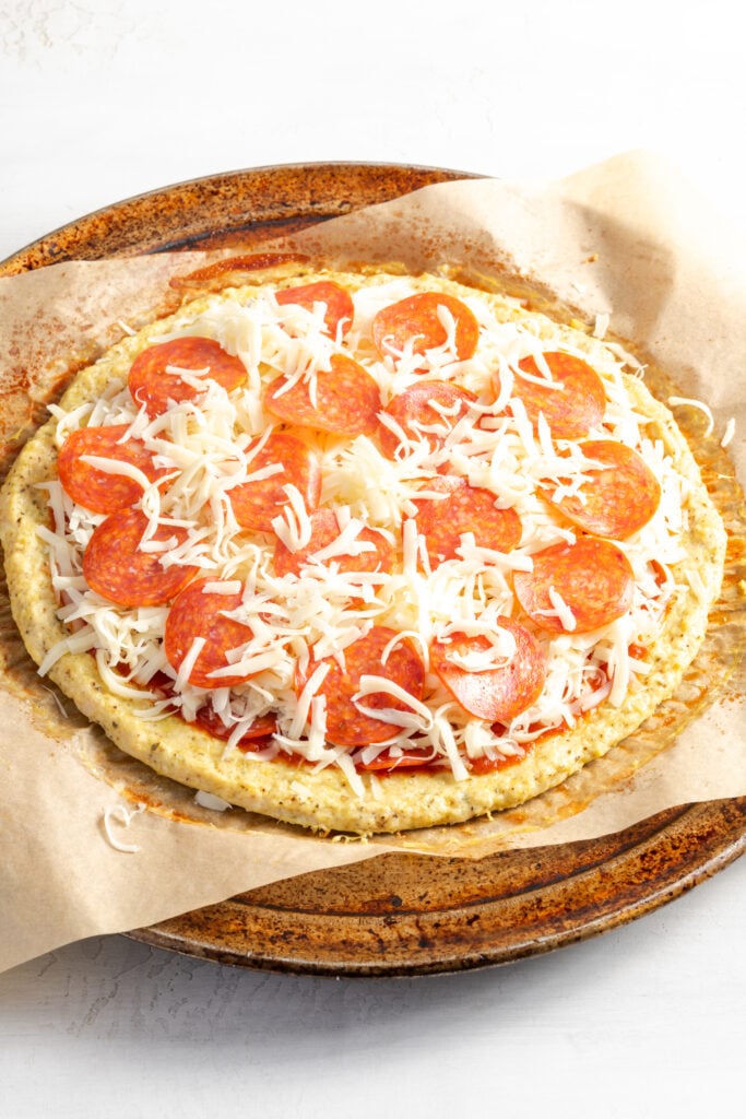 chicken pizza crust with sauce, cheese and pepperoni before baking.
