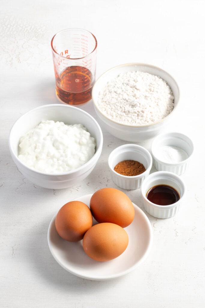 ingredients needed to make cottage cheese pancakes measured out on a white table.
