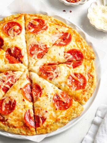 pepperoni pizza with a ground chicken crust after baking and slicing.