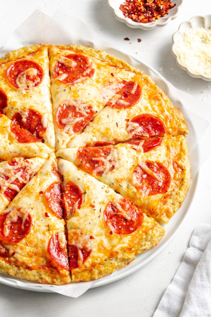 pepperoni pizza with a ground chicken crust after baking and slicing.