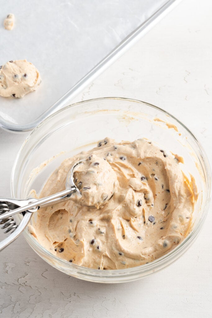 cookie scoop scooping out frozen yogurt peanut butter balls.