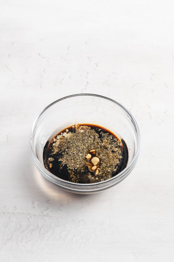 balsamic vinaigrette/marinade ingredients added to a small mixing bowl.