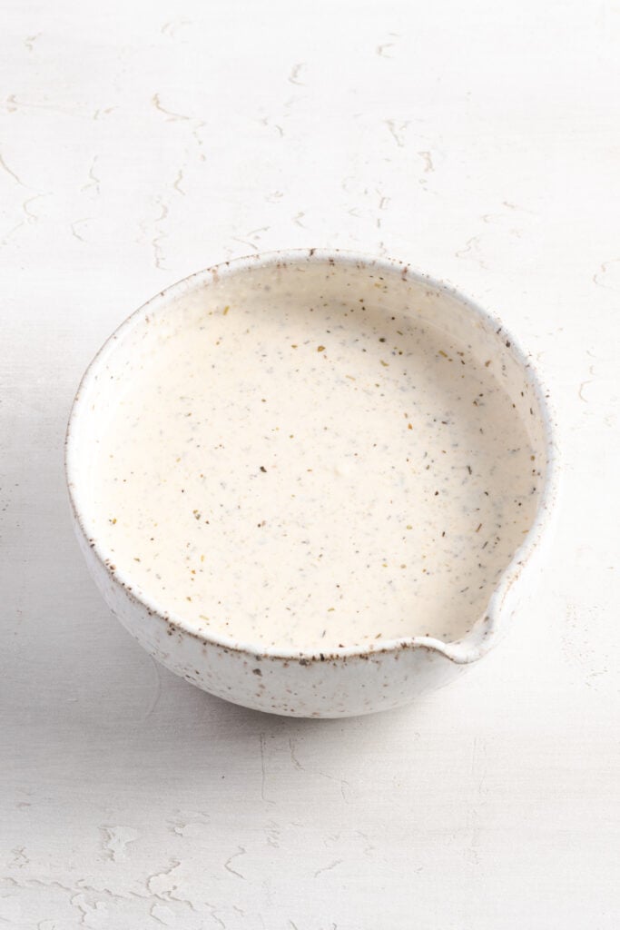 creamy grinder salad dressing in a small white mixing bowl.