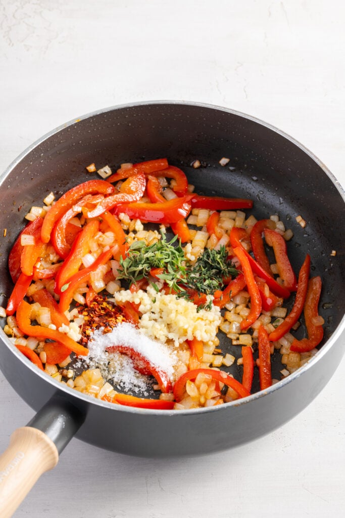 peppers, onions, garlic, and spices being sauteéd in a nonstick skillet.